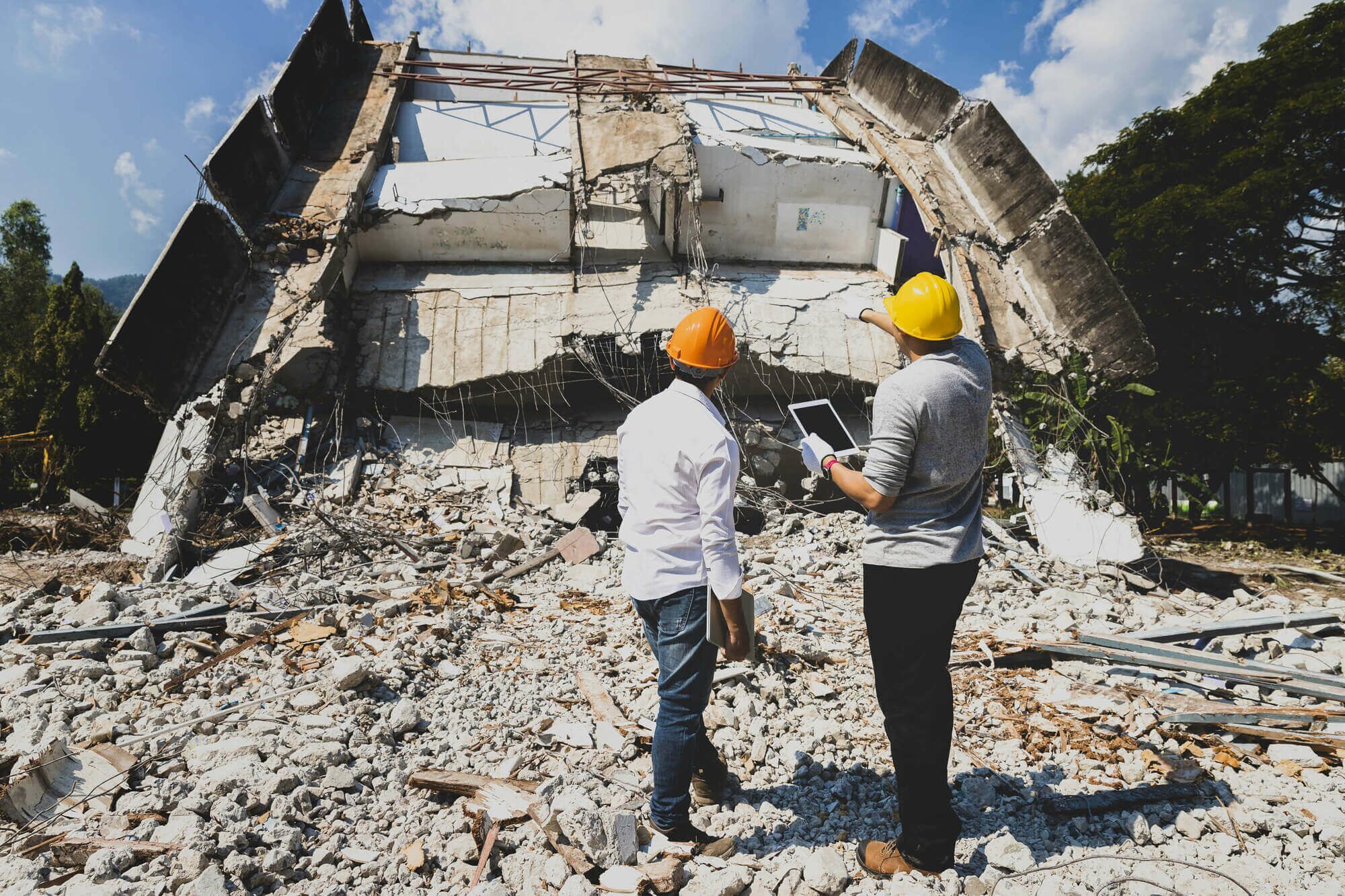 Abrisskontrolleur und Bauunternehmer diskutieren über den Abriss eines Gebäudes